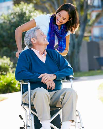 A caregiver helping a man in a wheelchair.